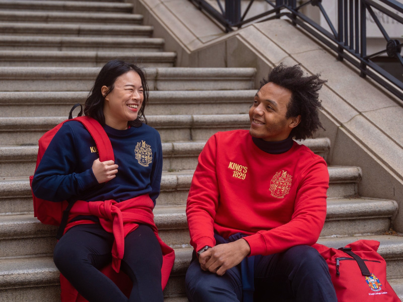 A blue tote bag with the KCL crest